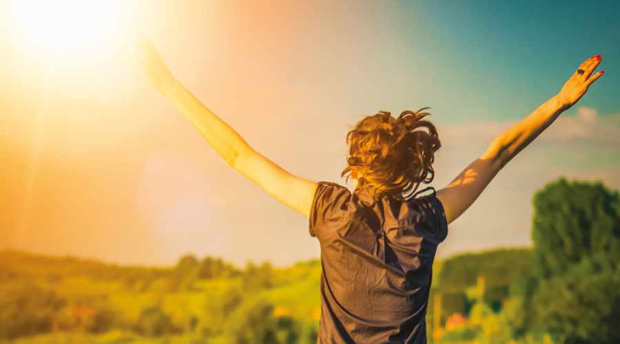 person with arms outstretched in sunshine