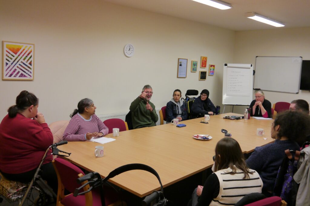 A photo of LCiL Champions' sitting at a table, smiling at the camera during a meeting